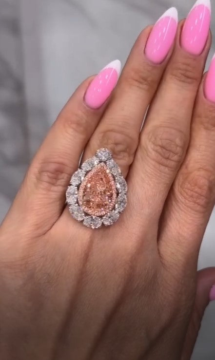 A radiant pear shape pink moissanite diamond in the center, wrapped in a soft pink halo and framed with brilliance. Pure luxury in every detail